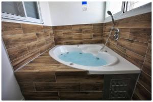 贝特谢安סוויטת אדל的带浴缸和木瓷砖的浴室