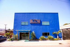 戈亚斯州上帕莱索Pousada Araras的蓝色的建筑,边有窗户