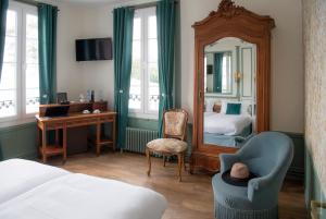 勒阿弗尔Hotel de Charme La Bonne Adresse的一间卧室配有一张床、镜子和椅子