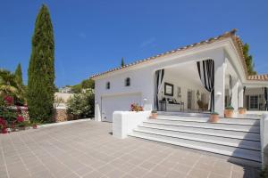 桑帕克Menorca Villa Marbella的白色的房子,设有楼梯和车库