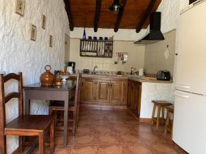格拉纳迪利亚德亚沃纳Casa rural las perez的厨房配有木制橱柜、桌子和冰箱。