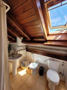 Portilla de la ReinaEl Invernal de Picos的一间带卫生间、水槽和窗户的浴室