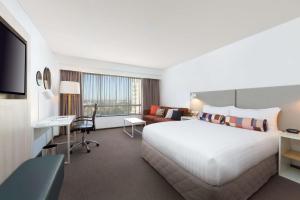 悉尼帕拉马塔莱吉斯酒店的酒店客房设有一张白色大床和一张书桌