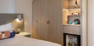 悉尼帕拉马塔莱吉斯酒店的一间卧室配有一张床和一个带冰箱的橱柜