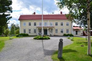 谢莱夫特奥Stiftsgården Hostel Skellefteå的一座白色的大建筑,有红色的屋顶