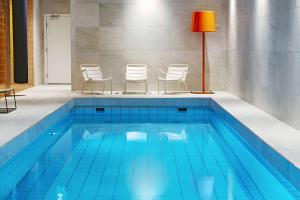 哥德堡斯堪迪克贝克戴尔酒店的一个带椅子和红灯的游泳池