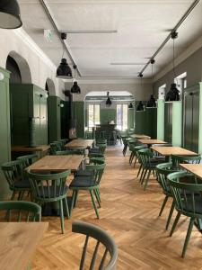 艾森纳赫Gästehaus Phantasie的一间设有木桌和绿色椅子的自助餐厅