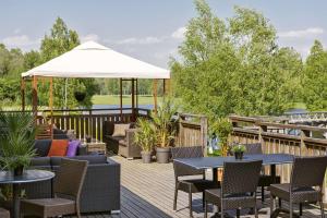 卡尔斯塔德斯堪迪克卡拉文酒店的庭院配有桌椅和白色遮阳伞。