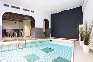 特罗尔海坦斯堪迪克思万尼尔酒店的一个带瓷砖地板和大屏幕的游泳池