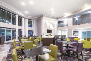 奥斯汀拉金塔套房酒店 - 奥斯汀机场的一间带桌子和黄色椅子的餐厅