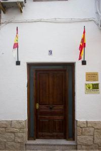 EscalonaCasa Rural Placida的门前有两面旗帜的建筑物