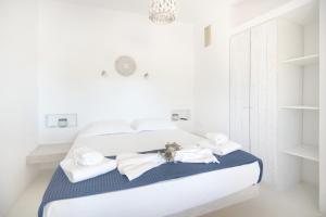 克里希阿克提Andria's suites的白色卧室,配有带毛巾的床