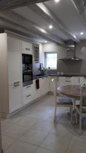 SteigeAppartement Béthanie的厨房配有白色橱柜和木桌