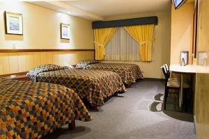 利马Los Mirtos suite & Hotel的酒店客房,设有3张带黄色窗帘的床