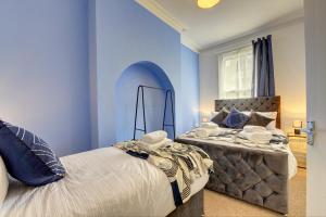 莱斯特Beautiful Victorian 2 Bedroom Flat的蓝色的卧室设有床和窗户