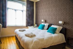 奥斯坦德尚布尔多住宿加早餐旅馆的卧室配有带蓝色枕头的大型白色床