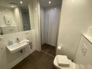 爱尔福特City Apartments的白色的浴室设有水槽和淋浴。