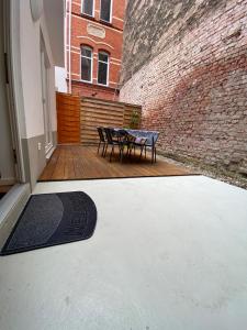爱尔福特City Apartments的砖墙上带桌子和长凳的庭院