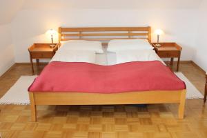 韦尔特湖畔克伦彭多夫柯布旅馆的一间卧室配有一张带红色毯子的大床