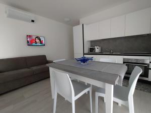 利多迪耶索罗Jesolo Appartamenti F2 - Ocean Blue的厨房配有桌椅和沙发。