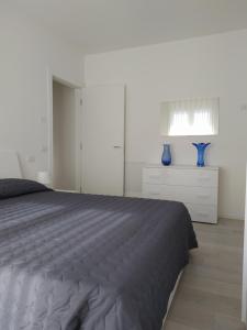 利多迪耶索罗Jesolo Appartamenti F2 - Ocean Blue的一间卧室配有一张床和两件蓝色花瓶