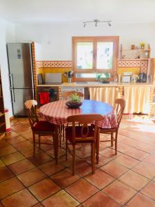 圣马丹韦叙比耶Rez de jardin de chalet bois , calme et verdure !的厨房配有桌椅和冰箱。