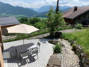施瓦岑贝格Bregenzerwaldblick的庭院配有遮阳伞和桌椅。