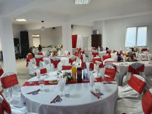 CîmpeniPENSIUNEA ANAIS的大房间设有白色桌子和红色椅子