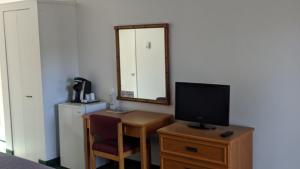 MattawaValois Motel & Restaurant的客房设有一张带电视和镜子的书桌
