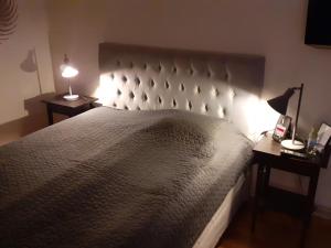 FinspångAlléhotellet的一间卧室配有一张大床,桌子上放着两盏灯