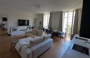 比亚里茨Sublime appartement centre, parc et parking的客厅配有白色的沙发和桌子