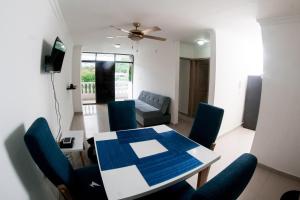 RodaderoRodadero Apartment的客厅配有桌子和蓝色椅子