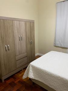 里约热内卢Copacabana Rio praia 6的一间卧室配有一张床和两个木制橱柜。
