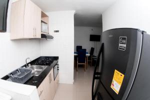 RodaderoRodadero Apartment的厨房配有黑色冰箱和桌子