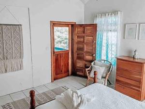 库尔克岛Vacation Home Blue Lotus- Gold Standard Certified的卧室配有床、椅子和窗户。