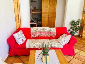圣马丹韦叙比耶Rez de jardin de chalet bois , calme et verdure !的客厅里一张红色的沙发,配有桌子