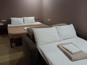 桑托斯将军城AB Star Suites的酒店的客房 - 带2张带白色枕头的床