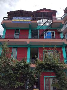 博卡拉Harry Guest House & Restaurant的一座红色的建筑,上面有标志