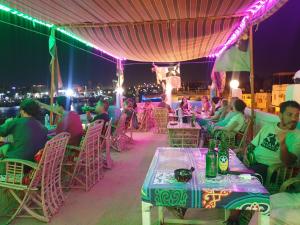 阿斯旺Bob Marley Guest House的一群人晚上坐在屋顶的桌子上