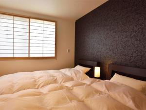 京都ShukuShuku的卧室内的一张大白色床,带有窗户