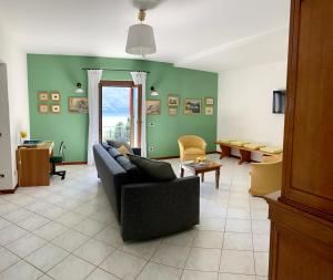 特雷梅佐La Dolce Vista的客厅设有黑色沙发和绿色的墙壁。