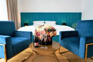 奥拉迪亚Hotel Glory的一间设有一张床和一张花束桌子的房间