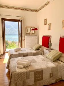 特雷梅佐La Dolce Vista的带大窗户的客房内的两张床
