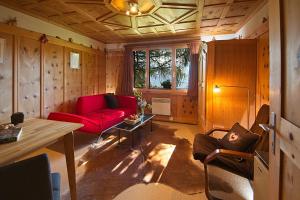 芙露姆赛山Flumserberg的客厅配有红色的沙发和桌子