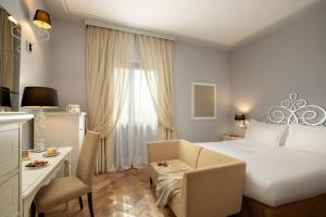 维泰博Alla Corte Delle Terme Resort的酒店客房配有一张床、一把椅子和一张书桌