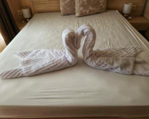 瓦尔纳Elegantz Apartments LaMer的两个天鹅坐在床上,带毛巾