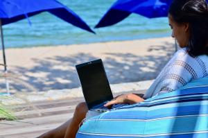 考陶Sanae Beach Hua Hin的坐在海滩上的女士,手提电脑