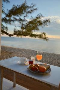 考陶Sanae Beach Hua Hin的一张桌子,上面有一盘食物和饮料在沙滩上