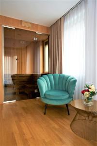 奥拉迪亚Hotel Glory的客厅配有蓝色椅子和桌子