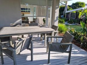 罗斯巴德Beachside Rosebud Retreat with *Wheelchair access*的天井上的木桌和椅子